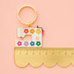 Keychain with sewing machine design and colorful flowers on a pink background