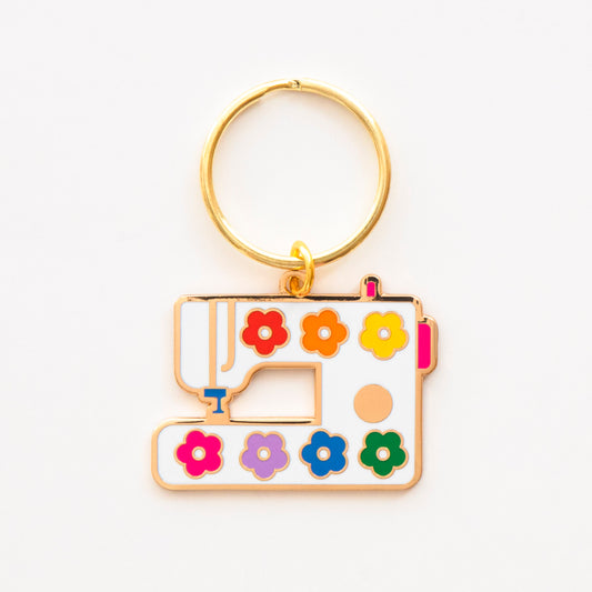 Keychain shaped like a sewing machine with colorful flowers on a white background